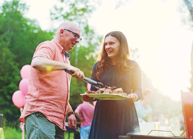 Photograph of man and woman barbecuing